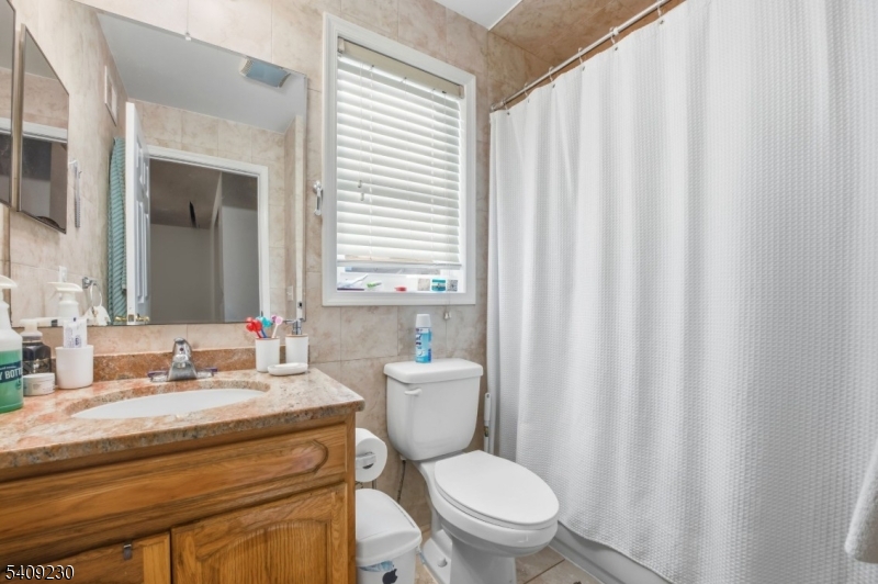 637 Jefferson Avenue Elizabeth, NJ 07201 - Photo 15 of 18 a bathroom with a toilet a sink and a mirror