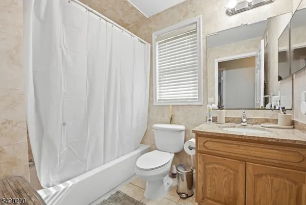 a bathroom with a granite countertop sink toilet and mirror