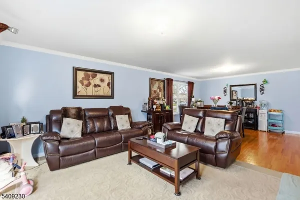 a living room with furniture and a painting on the wall