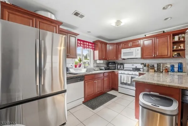 a kitchen with stainless steel appliances granite countertop a refrigerator sink and stove