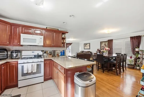 a open kitchen with stainless steel appliances granite countertop a stove and a refrigerator