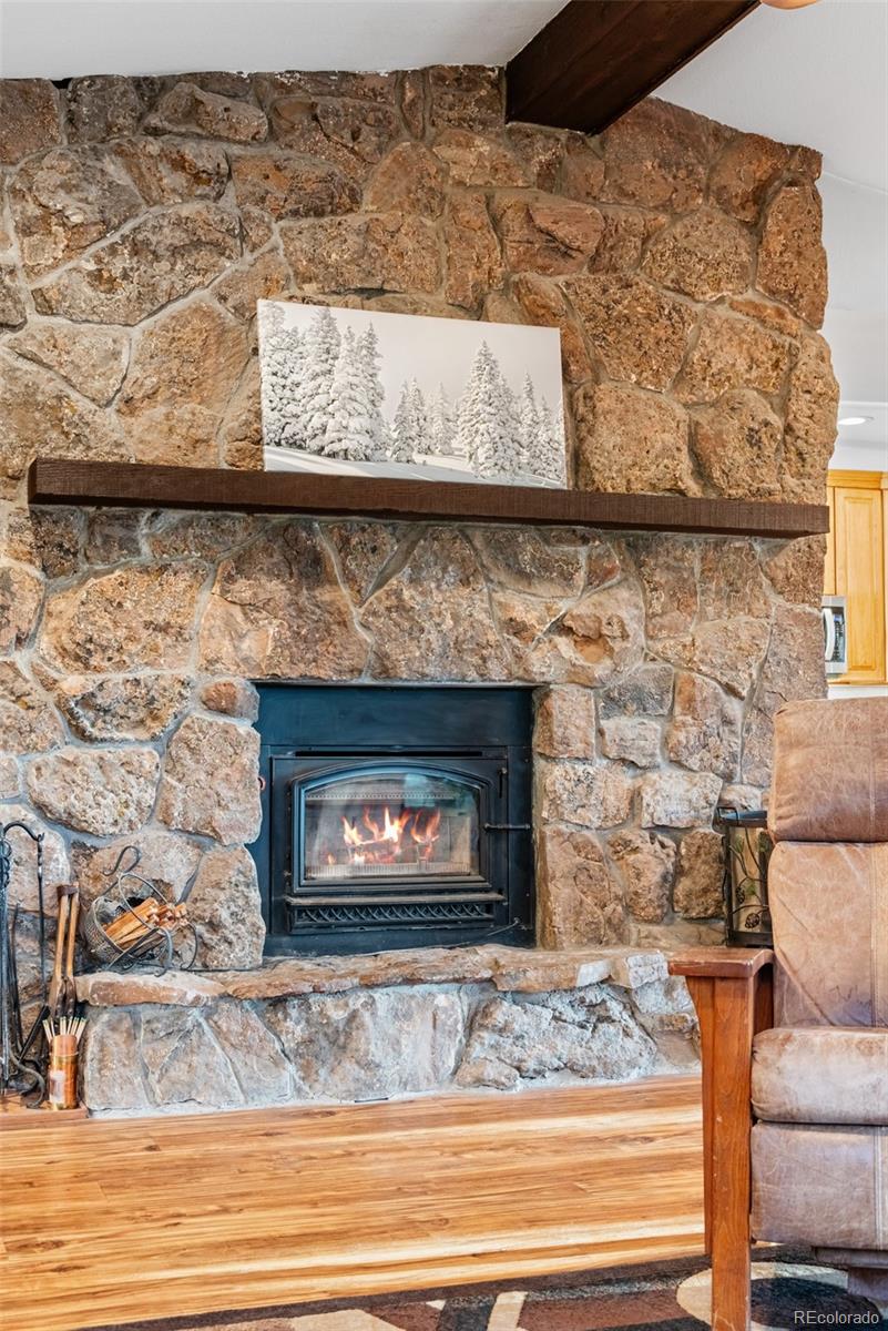 8440 South Warhawk Road Conifer, CO 80433 - Photo 14 of 48 a fireplace with a clock on wall