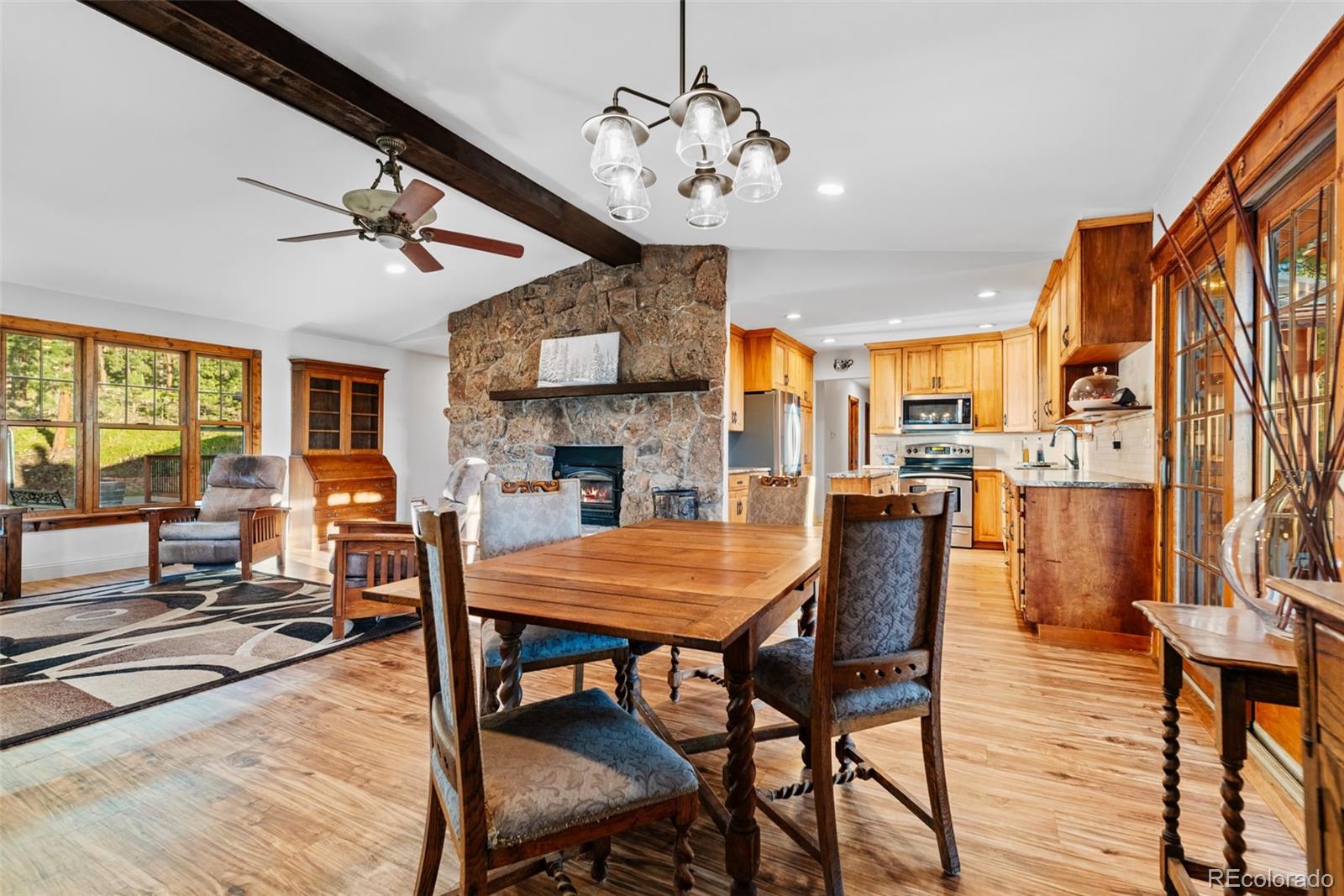8440 South Warhawk Road Conifer, CO 80433 - Photo 16 of 48 a dining room with furniture a chandelier and wooden floor