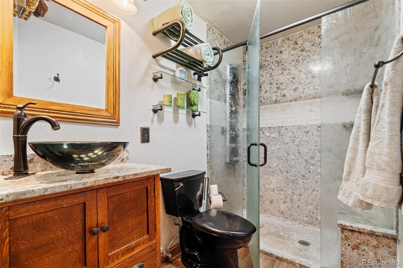 8440 South Warhawk Road Conifer, CO 80433 - Photo 21 of 48 a bathroom with a granite countertop sink a mirror and shower