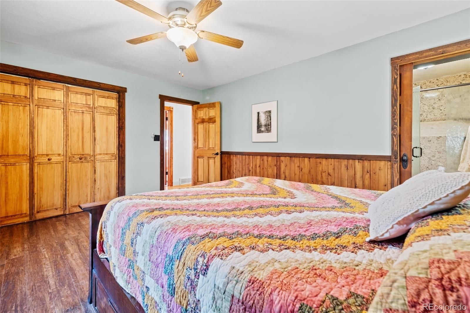 8440 South Warhawk Road Conifer, CO 80433 - Photo 24 of 48 a bedroom with a bed and a chandelier