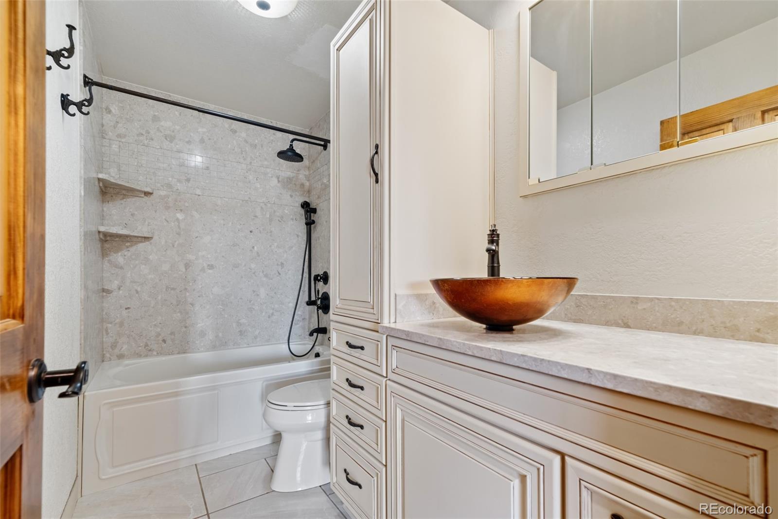 8440 South Warhawk Road Conifer, CO 80433 - Photo 25 of 48 a bathroom with a granite countertop sink a toilet and shower