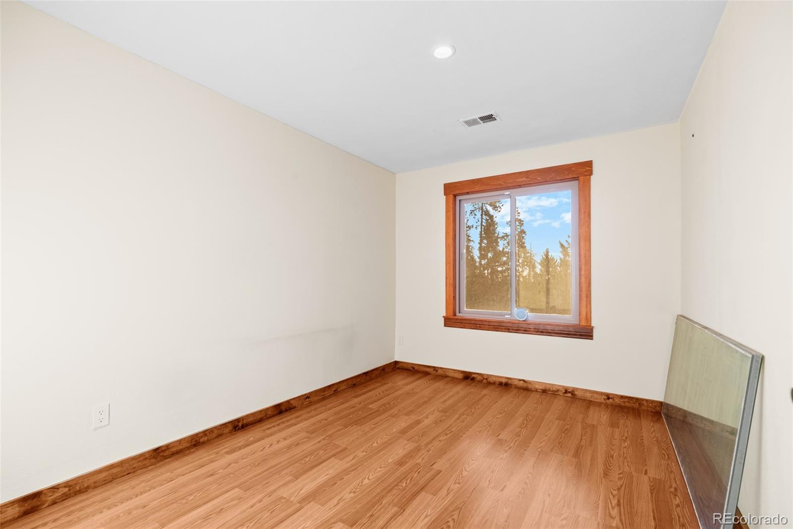 8440 South Warhawk Road Conifer, CO 80433 - Photo 35 of 48 a view of an empty room with wooden floor and a window