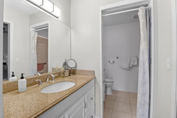 a bathroom with a granite countertop sink and a mirror