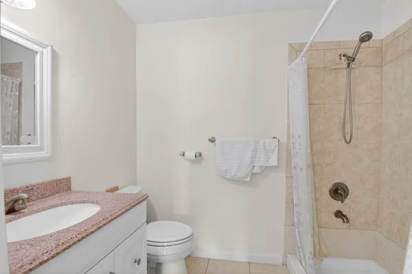 a bathroom with a granite countertop sink toilet and shower