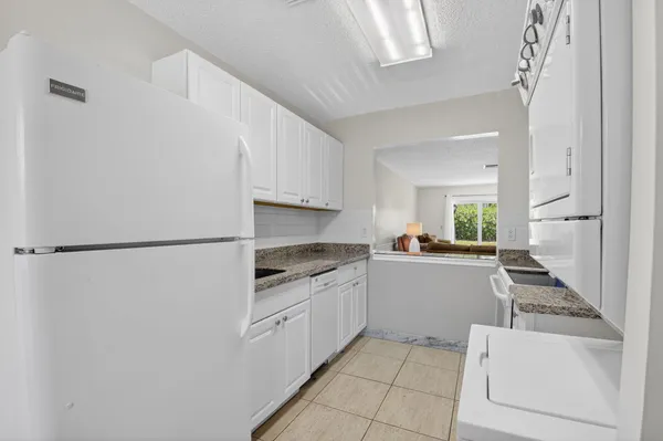 a kitchen with white cabinets and white appliances
