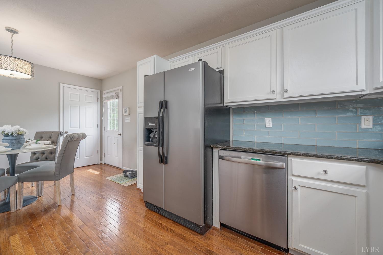 7179 Stage Road Concord, VA 24538 - Photo 11 of 52 a kitchen with stainless steel appliances granite countertop a refrigerator a sink dishwasher and white cabinets with wooden floor