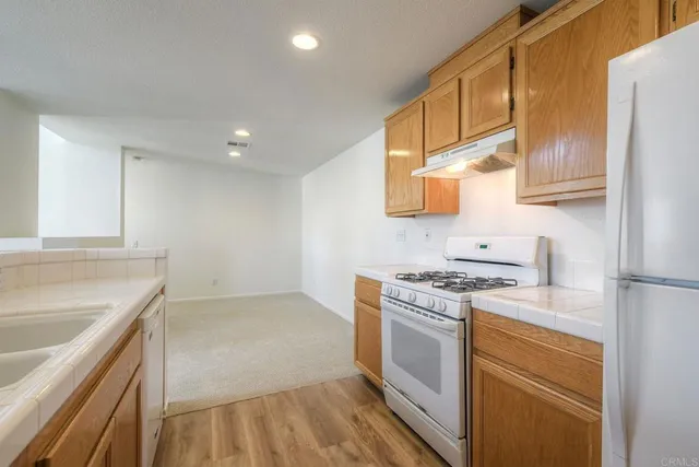 a kitchen with a sink stove top oven and refrigerator