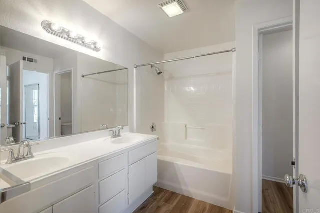 a bathroom with a bathtub shower sink vanity and a mirror