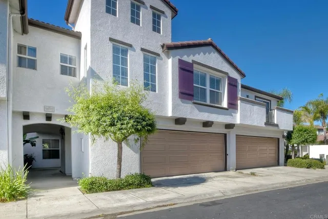 a front view of a house with plants
