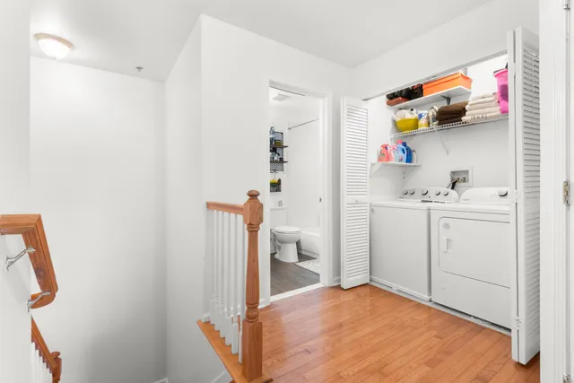 a view of a kitchen with white cabinets and wooden floor
