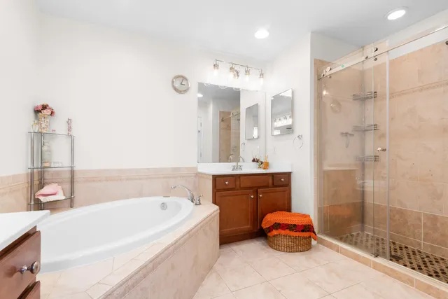 a bathroom with a tub sink and mirror