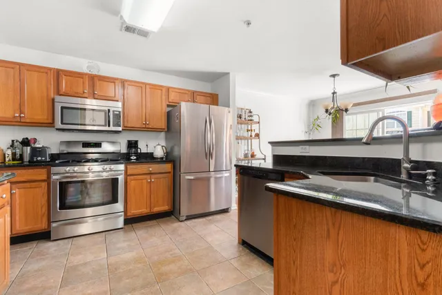 a kitchen with stainless steel appliances granite countertop a sink stove and refrigerator