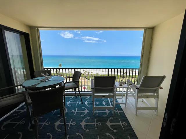 a balcony with wooden floor table and chairs