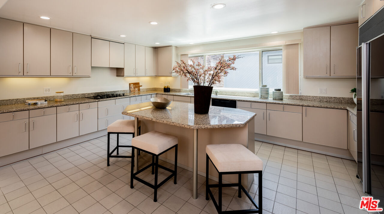 20 Voyage Street Marina del Rey, CA 90292 - Photo 7 of 28 a kitchen with stainless steel appliances granite countertop a table chairs sink and cabinets