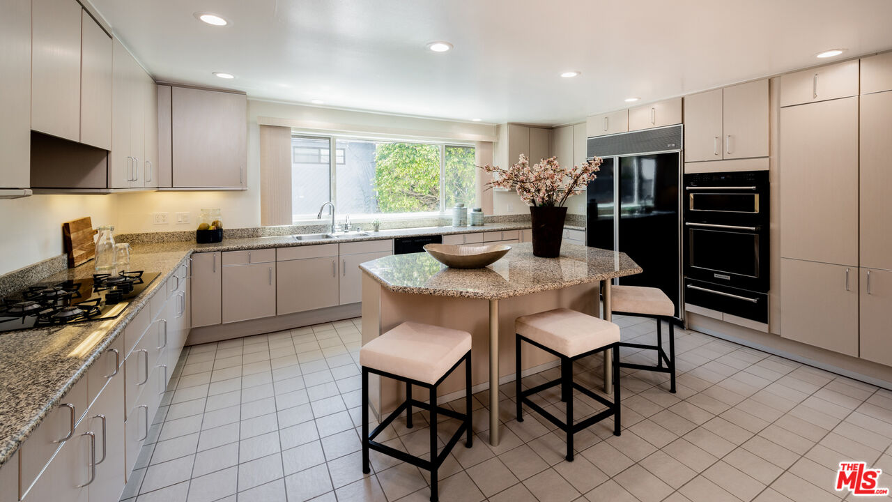 20 Voyage Street Marina del Rey, CA 90292 - Photo 8 of 28 a kitchen with stainless steel appliances granite countertop a stove a sink a microwave a refrigerator and chairs