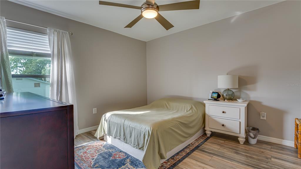 6145 113th Street, Unit 415 Seminole, FL 33772 - Photo 19 of 35 a bedroom with a bed and a chandelier