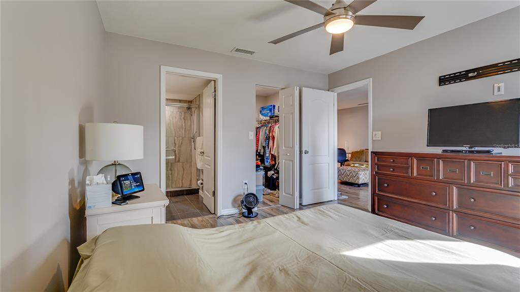 6145 113th Street, Unit 415 Seminole, FL 33772 - Photo 21 of 35 a bedroom with a bed and a flat screen tv