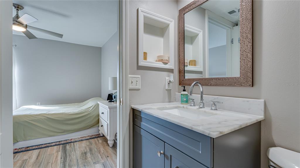 6145 113th Street, Unit 415 Seminole, FL 33772 - Photo 25 of 35 a bathroom with a granite countertop sink and a mirror
