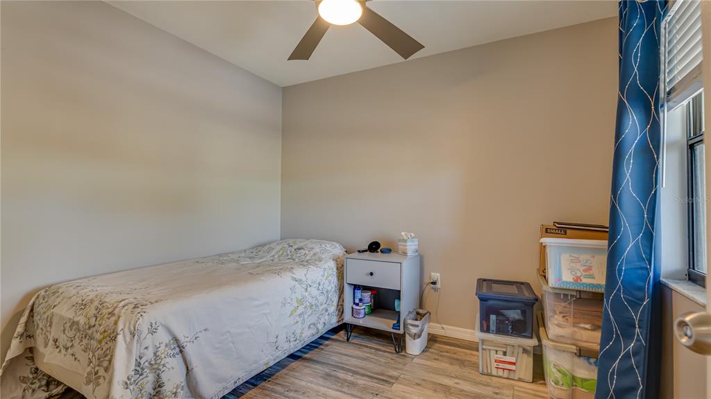 6145 113th Street, Unit 415 Seminole, FL 33772 - Photo 28 of 35 a bedroom with a bed and wooden floor