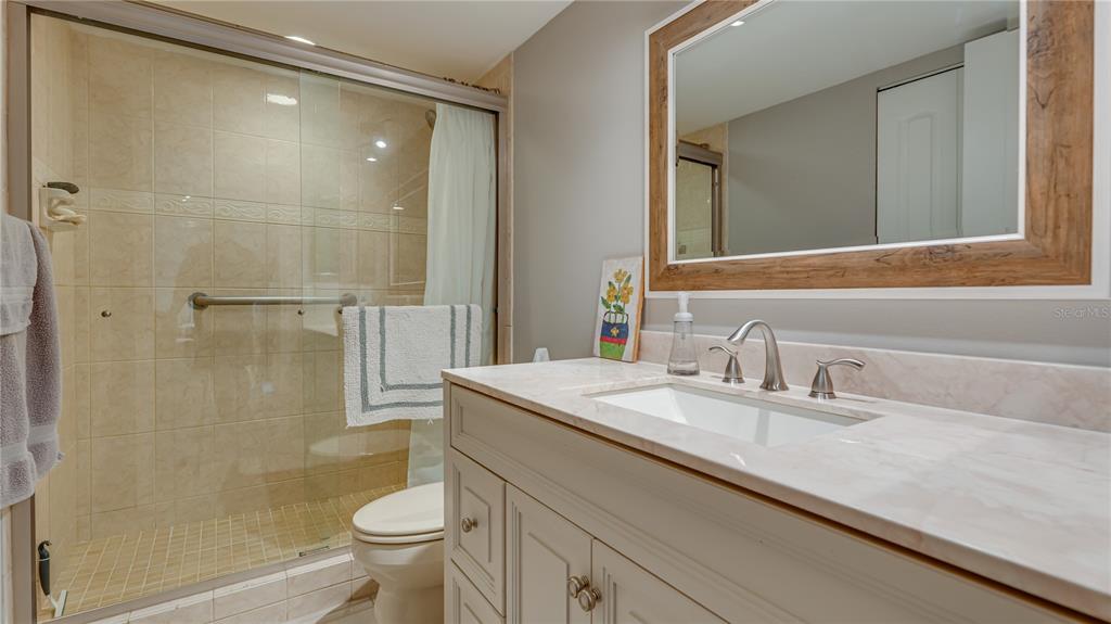 6145 113th Street, Unit 415 Seminole, FL 33772 - Photo 30 of 35 a bathroom with a sink a toilet and shower