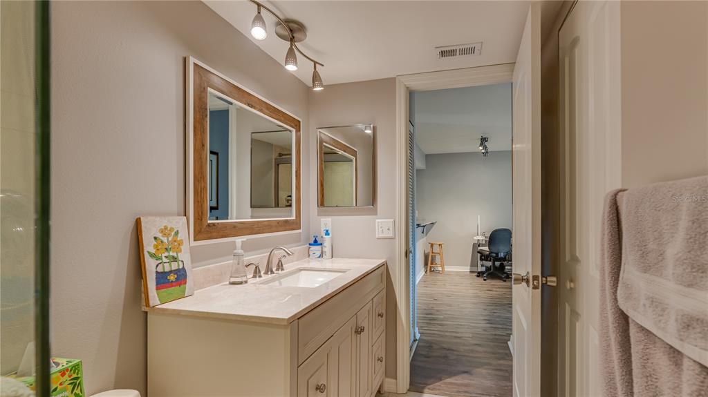6145 113th Street, Unit 415 Seminole, FL 33772 - Photo 31 of 35 a bathroom with a sink a mirror and a shower