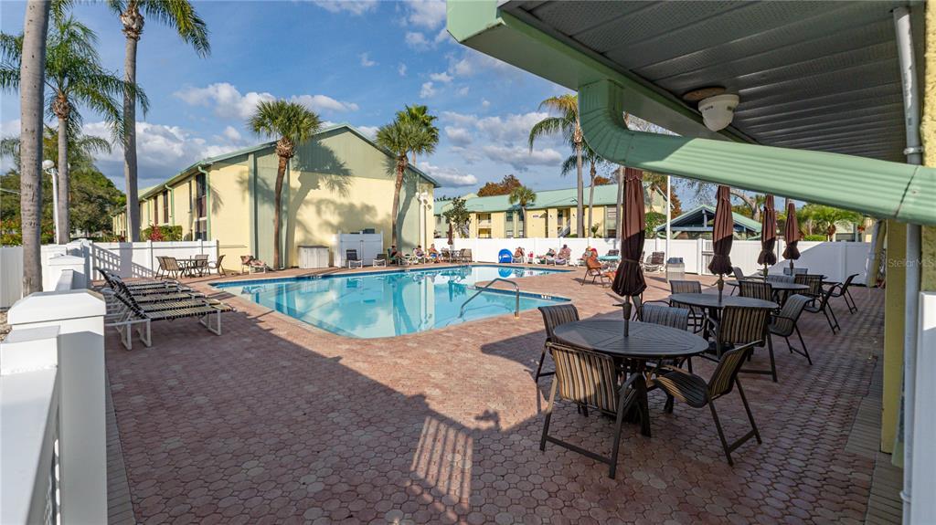 6145 113th Street, Unit 415 Seminole, FL 33772 - Photo 34 of 35 a view of a patio with a table and chairs