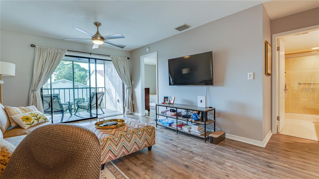 6145 113th Street, Unit 415 Seminole, FL 33772 - Photo 5 of 35 a living room with furniture and a flat screen tv