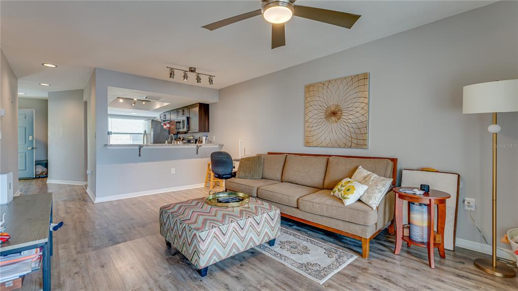 6145 113th Street, Unit 415 Seminole, FL 33772 - Photo 8 of 35 a living room with furniture and a wooden floor