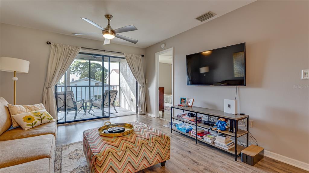 6145 113th Street, Unit 415 Seminole, FL 33772 - Photo 9 of 35 a living room with furniture and a flat screen tv