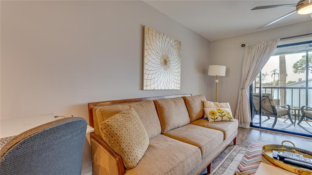 6145 113th Street, Unit 415 Seminole, FL 33772 - Photo 10 of 35 a blue couch sitting in front of a window