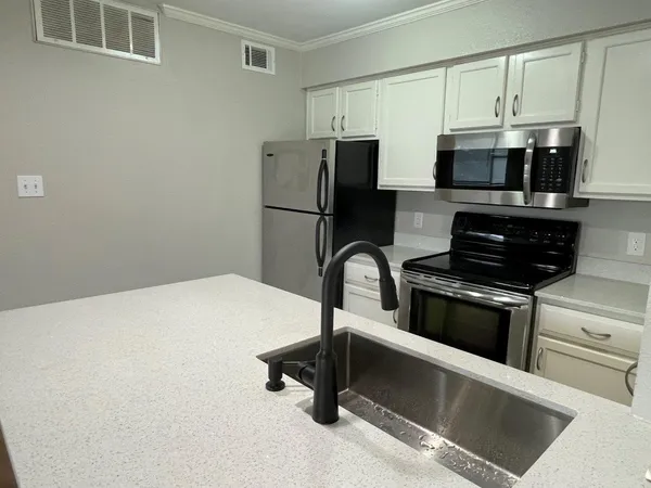 a kitchen with stainless steel appliances a refrigerator and a stove top oven