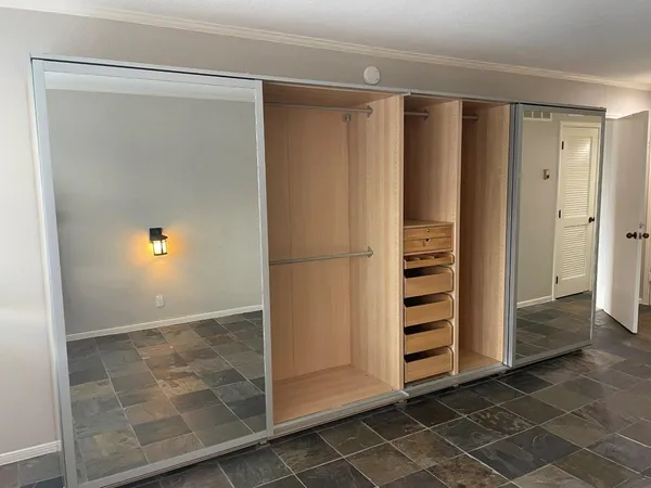 a view of walk in closet with empty racks