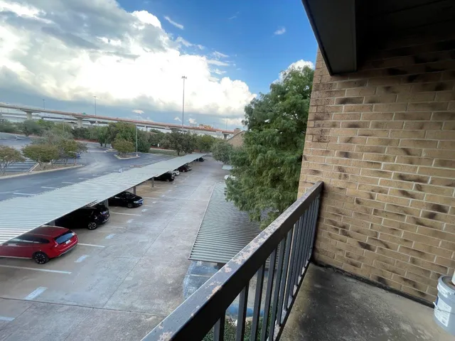 a view of a balcony with wooden floor and fence