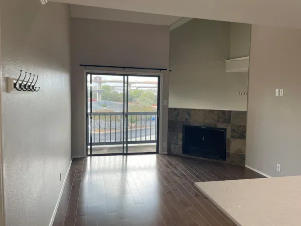 an empty room with wooden floor and a fireplace