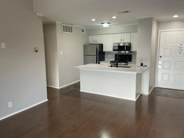 a view of kitchen with stainless steel appliances a refrigerator and a stove top oven