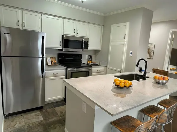 a kitchen with a sink a refrigerator and a stove top oven