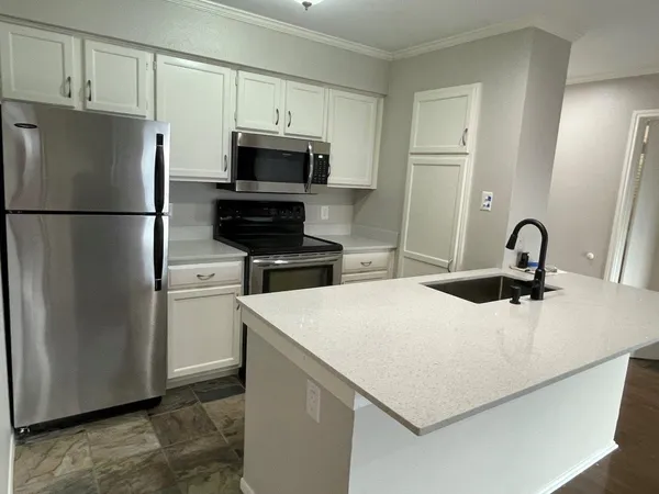 a kitchen with stainless steel appliances a refrigerator sink and white cabinets