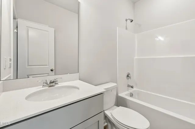 a bathroom with a sink toilet vanity and shower