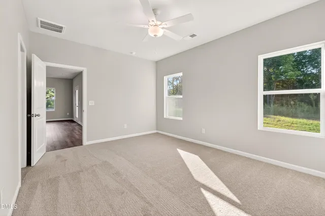 an empty room with windows and closet
