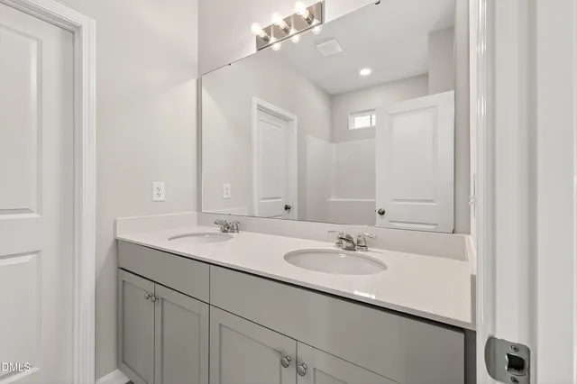 a bathroom with a sink double vanity and a mirror