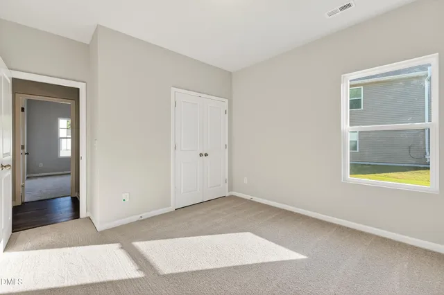 an empty room with windows and mirror