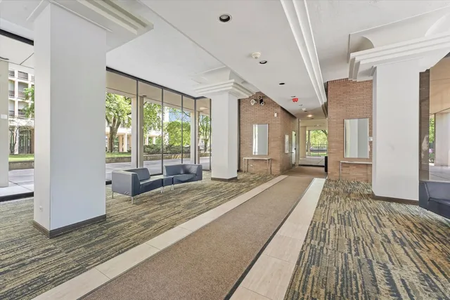 a spacious bedroom with a large window a bed and windows