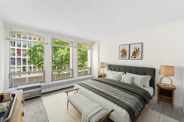 a bedroom with a bed and a large window