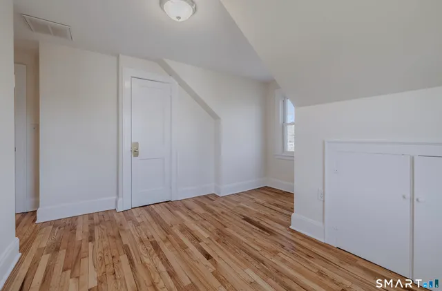 a view of an empty room with wooden floor