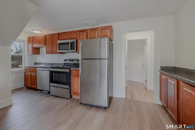 a kitchen with stainless steel appliances a stove a refrigerator and a sink
